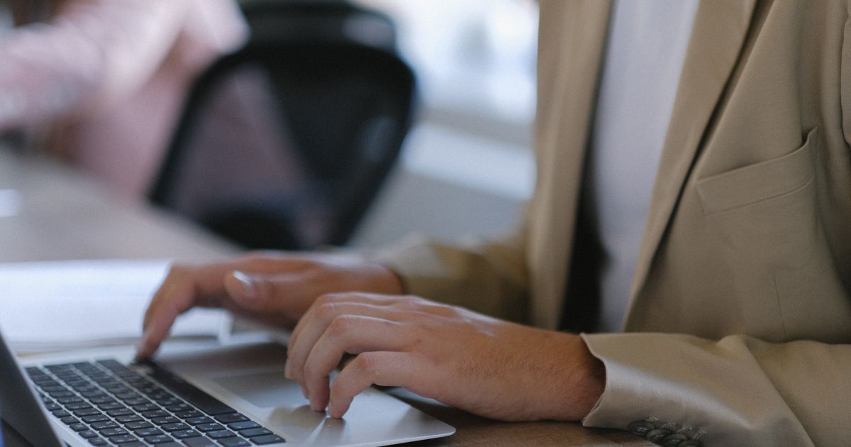A professional working on a laptop at a desk