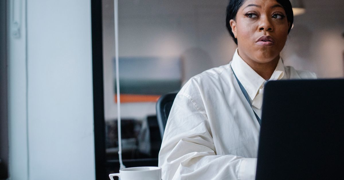 A focused professional working at a laptop in an office