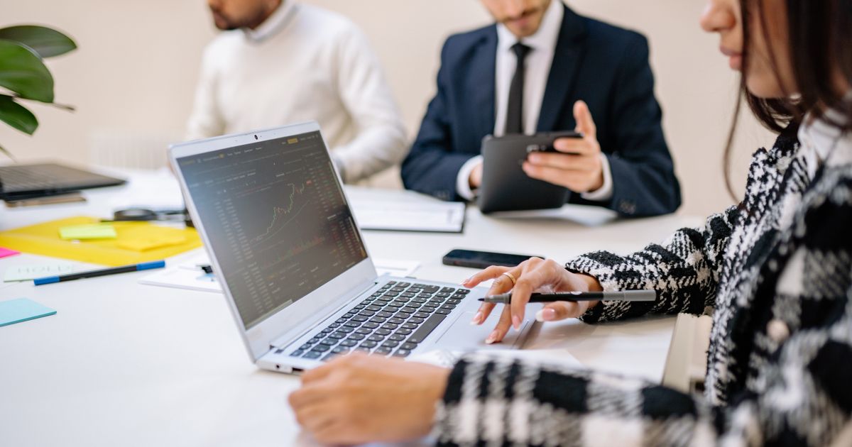 A small team reviewing work together on a laptop
