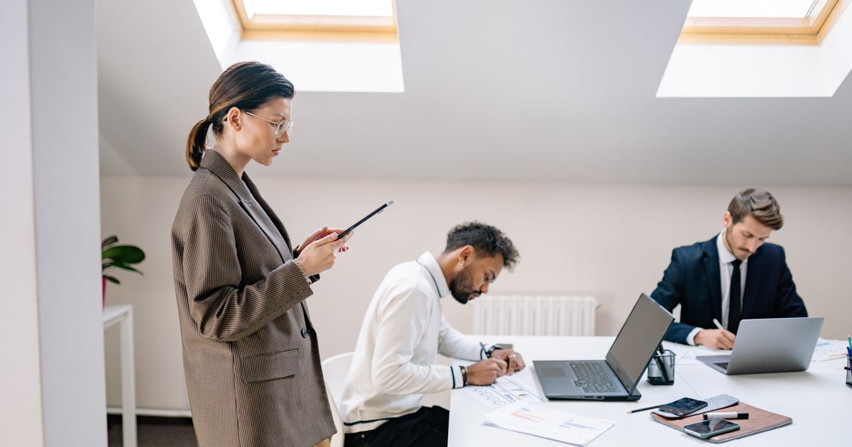 Professionals setting up and working at laptops in a bright modern office